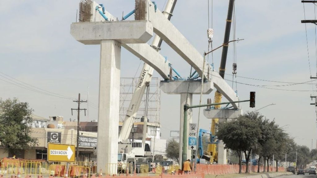 Construction Site with a Large Concrete Beam and Cranes over a Road; Orange Barriers and a Detour Sign Read 'desviación'. - Los Industriales